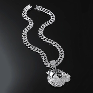 Detail view of silver Cuban chain with sparkling iced-out bulldog pendant on black background