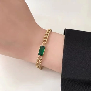 Minimalistisches Armband aus goldfarbenem Titanstahl mit grünem Kristallanhänger