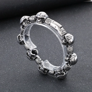 Macro shot of silver stainless steel skull link bracelet with textured beads and clasp