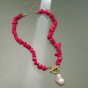 Detail of baroque pearl pendant with rose red stones and golden OT toggle clasp on necklace