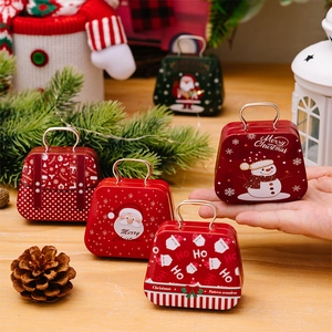 Christmas tinplate mini handbag boxes with Santa patterns being held by hand