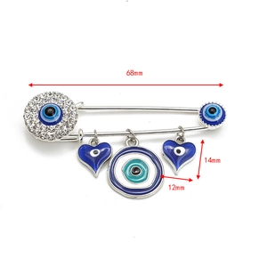 Detail view showing 68mm evil eye brooch dimensions with silver charms and rhinestones