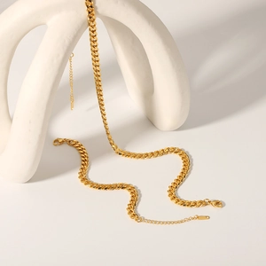 18K gold plated stainless steel Cuban link necklace displayed on white ceramic