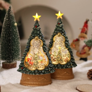 Close-up of glowing Christmas tree music box with Santa Claus and reindeer inside