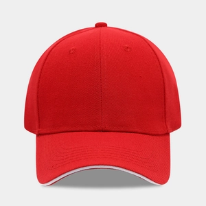 Front view detail of a classic red baseball cap with white sandwich visor and cotton texture