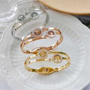 Detail of tree of life bangles with crystal accents in silver, gold, and rose gold finishes