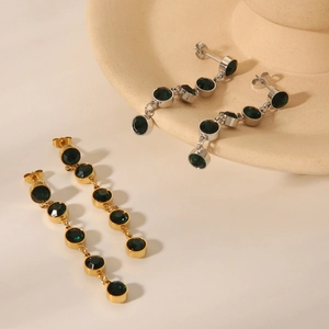 Detail of long tassel earrings with 18K gold and silver plating and green crystals