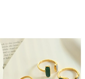 Detailed macro view of three adjustable gold plated rings with green and grey resin stones