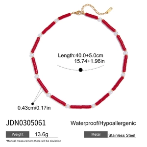 Macro shot of red natural stone and pearl beaded necklace with 18K gold stainless steel chain