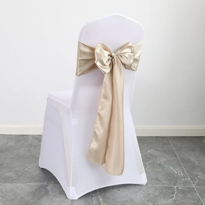 Elegant champagne gold satin chair sash tied in a large bow over a white seat cover