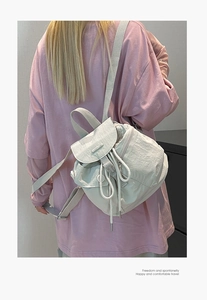 Detail of white nylon mini bucket backpack with drawstring closure and side pockets