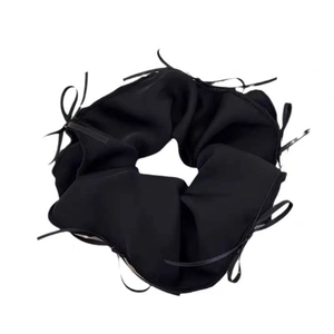 Close-up of black satin scrunchie with long decorative ribbons for ballet style hair
