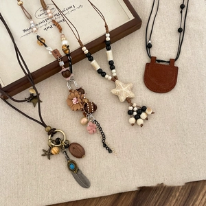 Detail view of vintage bohemian necklaces with wooden beads and feather charms