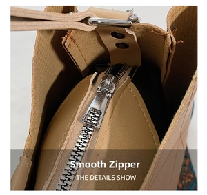 Close-up of a smooth silver metal zipper on a stylish beige leather handbag detail