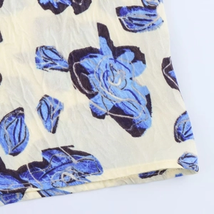 Vue macro détaillée du motif floral et des coutures soignées sur une jupe midi en satin