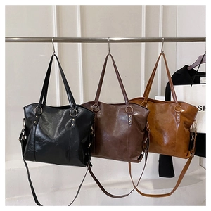 Three oversized oil leather tote bags in black, dark brown, and caramel colors
