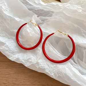 Close-up of red circular resin hoop earrings with secure gold-tone metal hooks