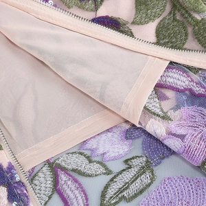 Detail of pink embroidered evening dress with purple floral sequins and metallic zipper