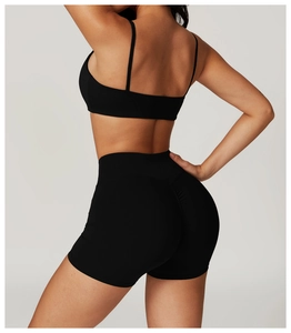 Detail view of black high-waisted fitness shorts and sports bra showing sculpting effect