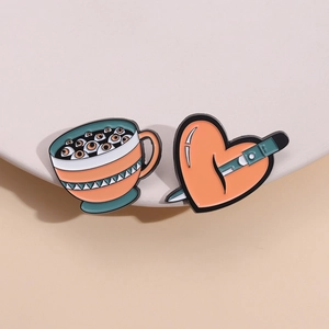 Halloween enamel pin set featuring a spooky eyeball coffee cup and orange pierced heart