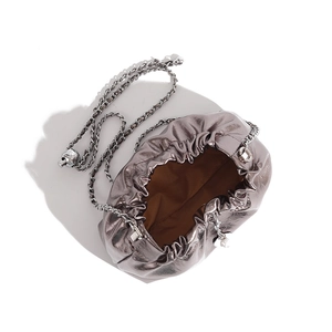 Top view of metallic grey pleated cloud bag showing brown lining and silver chain strap