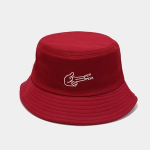 Gros plan sur la broderie Pew Pew blanche du chapeau bob en coton rouge foncé