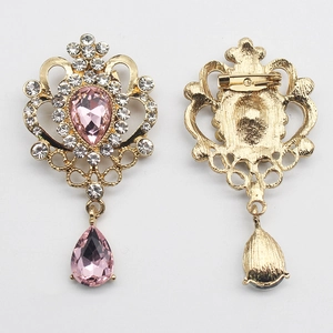 Vintage gold crown brooch with teardrop pink crystal and diamond-like accents