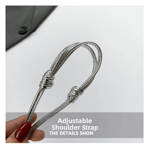 Details verstellbarer silberner Metallic-Gurte mit Schiebeknoten an roter herzförmiger Tasche
