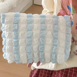 Close-up of blue and white striped bubble texture fabric on a large cosmetic bag