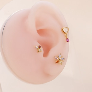 Pink zircon ear piercings with gold heart and butterfly studs shown on ear model