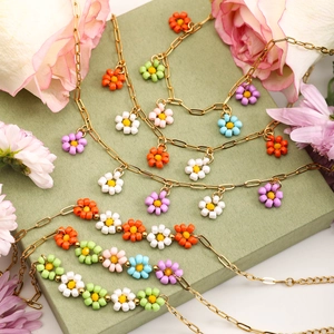 Detailed display of colorful beaded flower necklaces on a green gift box with flowers