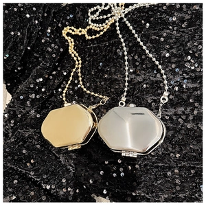 Detail showing mini octagonal metal bags in gold and silver with mirror finish and chain