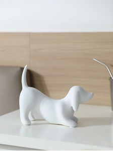 Detail view of a modern matte white puppy ceramic figurine in a minimalist home setting