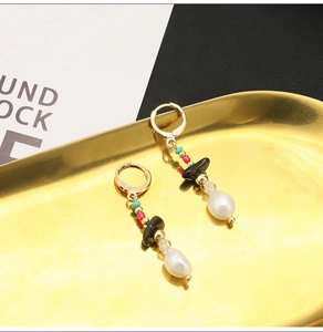 Macro shot of vintage baroque pearl earrings with black onyx on a gold tray