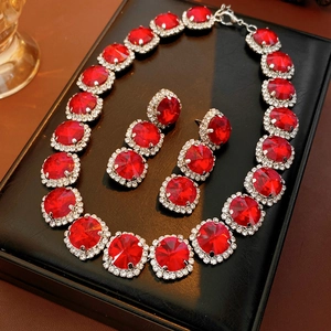 Nahaufnahme eines Luxus-Schmucksets mit roten Edelsteinen und Diamant-Halo-Details
