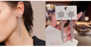 Close-up of sparkling silver snowflake tassel earrings worn by a model for elegant look