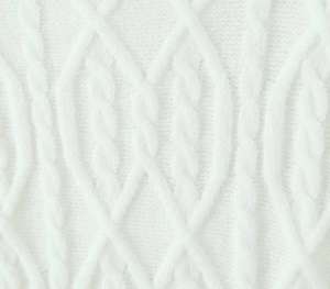 Close-up detail showing the intricate white cable knit pattern and texture of the fabric