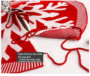 Detail of red knitted Christmas tree skirt featuring white snowflake and ribbon tie