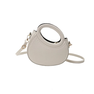 Cream striped saddle bag with a unique circular handle and adjustable shoulder strap