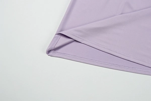 Detail of lavender knit fabric showing fine double-needle stitching and texture on the hem