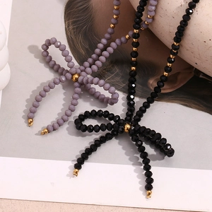 Détail d'un collier fait main avec des perles de cristal facettées et un pendentif nœud