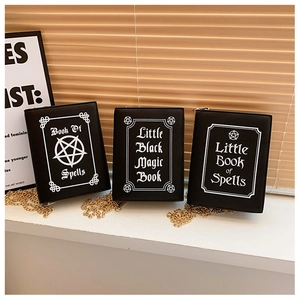 Detailed view of three vintage book-shaped crossbody bags with mystical spell book prints