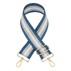 Close-up of adjustable navy and silver striped bag strap with gold metal buckles
