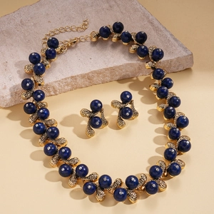 Vintage gold necklace and earrings set with blue beads and diamonds on stone plate