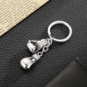 Detail of silver stainless steel boxing glove keychain pendants on black leather
