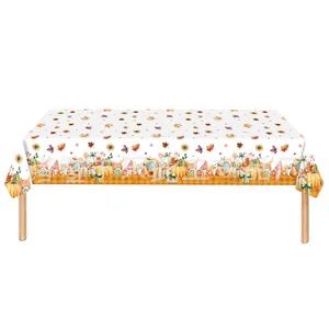 Close-up of Thanksgiving tablecloth with pumpkins, maple leaves and orange plaid edges
