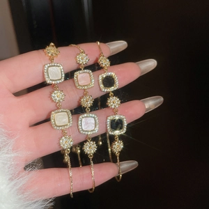 Détail de bracelets réglables plaqués or 18k avec zircons et pierres de nacre