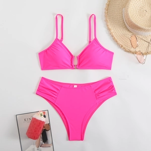 Close-up of neon pink bikini set featuring a metal ring connector and ruched side details