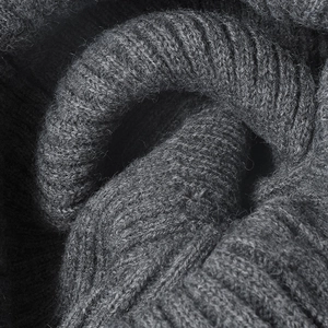Thick ribbed knit texture of a dark grey winter beanie showing double-layer warm material