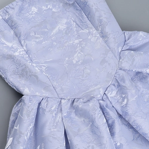 Detail of light purple jacquard fabric with elegant floral texture and pleated waist design
